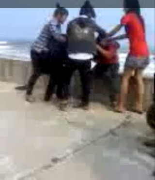 Một nhóm nữ sinh đang vây đánh 01 nữ sinh (mặc áo đỏ) cùng trường (ảnh từ video clip của một nữ sinh Trường THCS Hải Trạch có mặt lúc xảy ra vụ việc đã quay lại bằng ĐTDĐ).